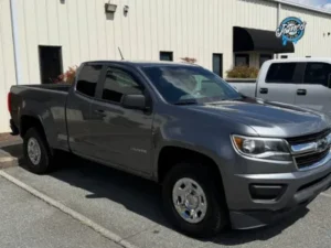 A technician using a rotary polisher to perform a professional paint correction.