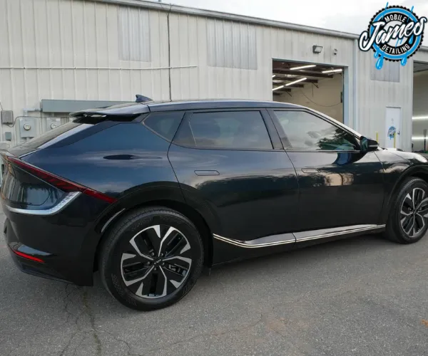 A side profile view of a dark blue electric crossover SUV with a sleek.